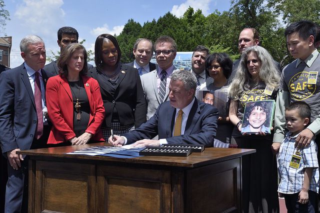 Mayor Bill de Blasio surrounded by lawmakers and transit advocates as he signs the first number of bills on June 23rd, 2014 as part of his “Vision Zero” initiative.